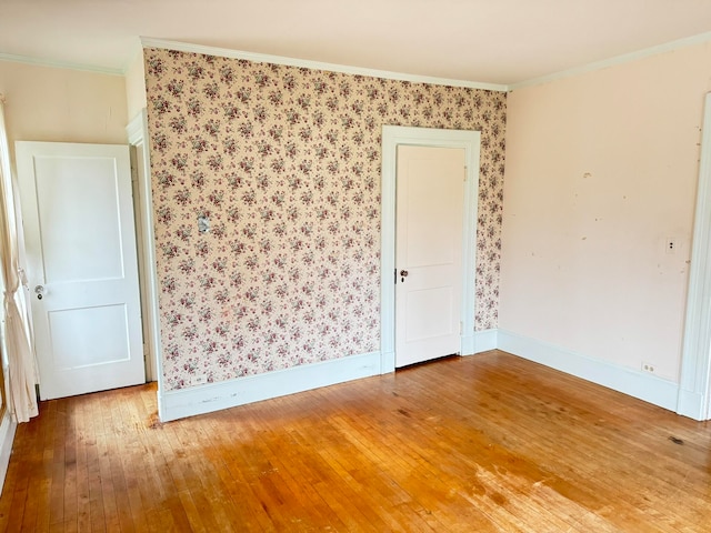 empty room featuring crown molding and light hardwood / wood-style flooring