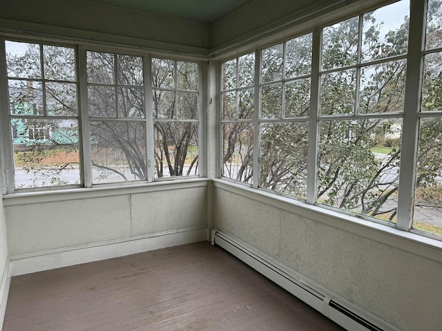 unfurnished sunroom featuring a baseboard heating unit