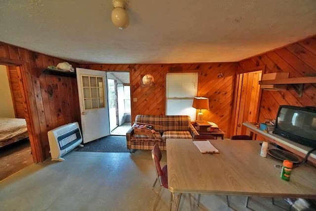 living room with a textured ceiling and wood walls