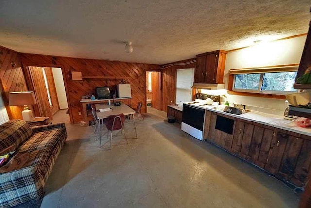 kitchen with white range with electric stovetop, a textured ceiling, sink, and wooden walls