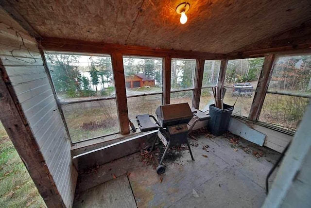 unfurnished sunroom featuring vaulted ceiling