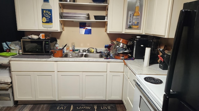 kitchen with white cabinetry, sink, and black appliances