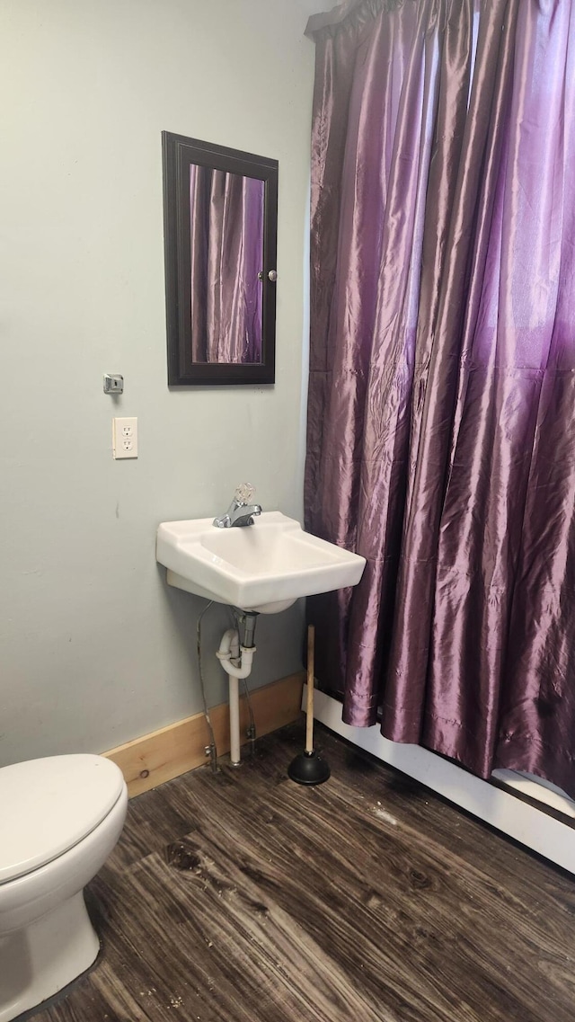 bathroom with hardwood / wood-style floors and toilet