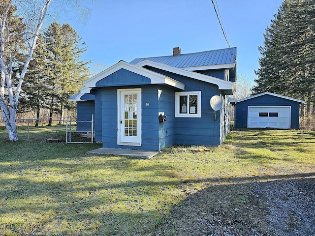 view of front of property featuring a garage, an outdoor structure, and a front yard