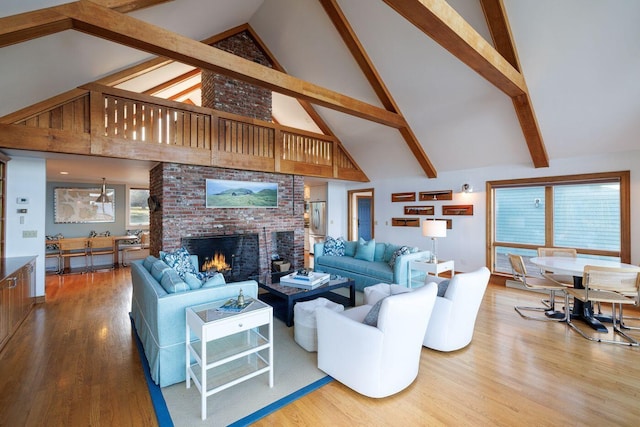 living room featuring high vaulted ceiling, a fireplace, brick wall, and hardwood / wood-style floors