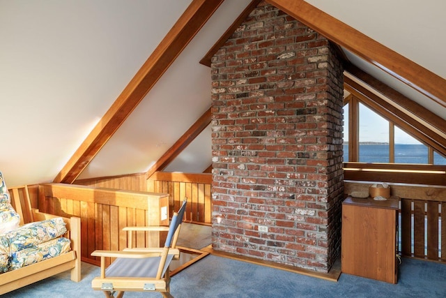 interior space featuring wood walls, lofted ceiling with beams, carpet, and brick wall