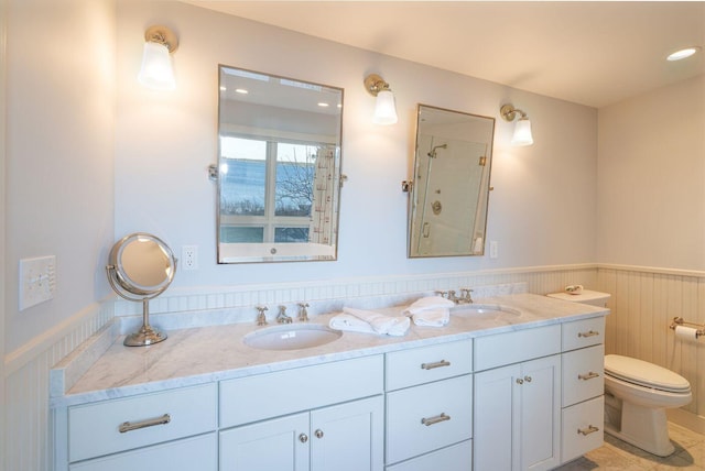 bathroom with double vanity and toilet