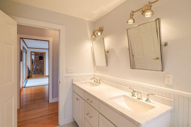 bathroom with dual bowl vanity and hardwood / wood-style flooring