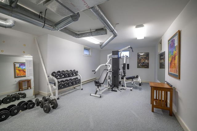 exercise room with baseboard heating and carpet