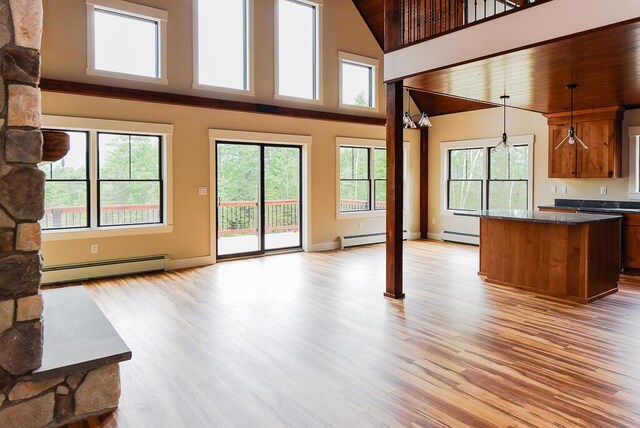 unfurnished living room with wooden ceiling, a baseboard radiator, and light wood-type flooring