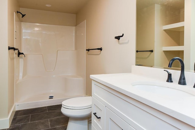 bathroom featuring tile patterned flooring, vanity, toilet, and walk in shower