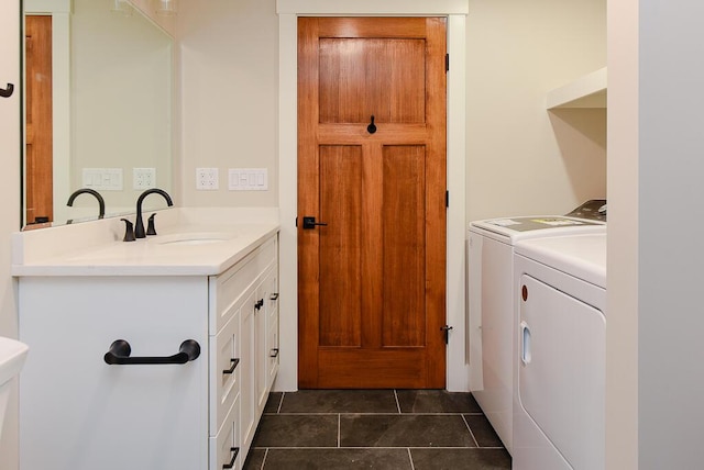 clothes washing area featuring washer and dryer, cabinets, and sink