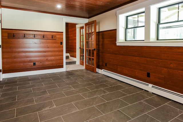 unfurnished room with a baseboard radiator, wood ceiling, and wood walls