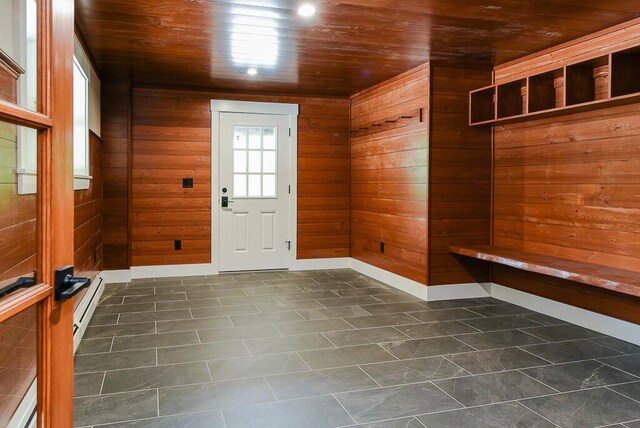 mudroom with wooden walls, wooden ceiling, and a baseboard heating unit