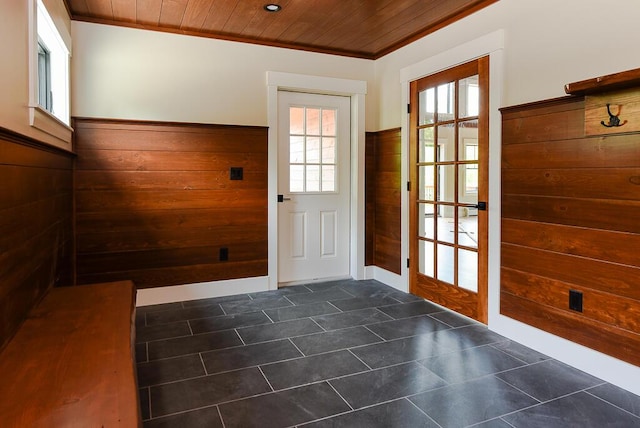 entryway with wood walls, wooden ceiling, and ornamental molding