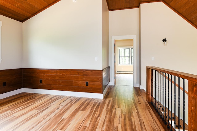 spare room featuring a baseboard radiator, wooden ceiling, crown molding, vaulted ceiling, and hardwood / wood-style flooring