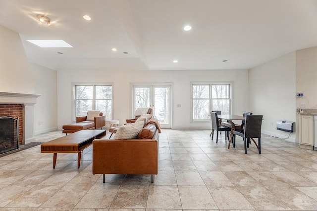 living room featuring a healthy amount of sunlight, a skylight, and a brick fireplace