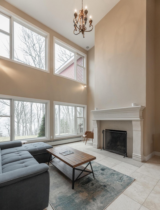 living room featuring a towering ceiling, a notable chandelier, light tile patterned floors, and plenty of natural light