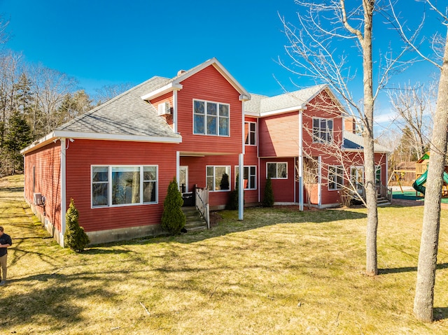 back of property with a lawn and a playground