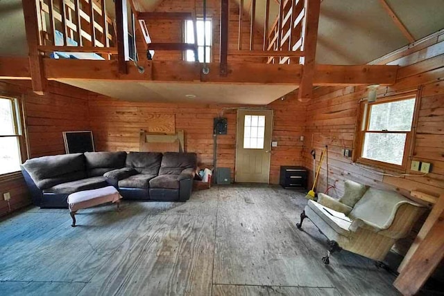 living room with beam ceiling, wood walls, hardwood / wood-style floors, and high vaulted ceiling