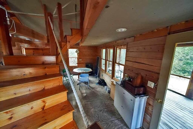 interior space with a fireplace, hardwood / wood-style floors, and wooden walls