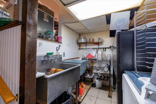 kitchen with a paneled ceiling and light tile patterned flooring