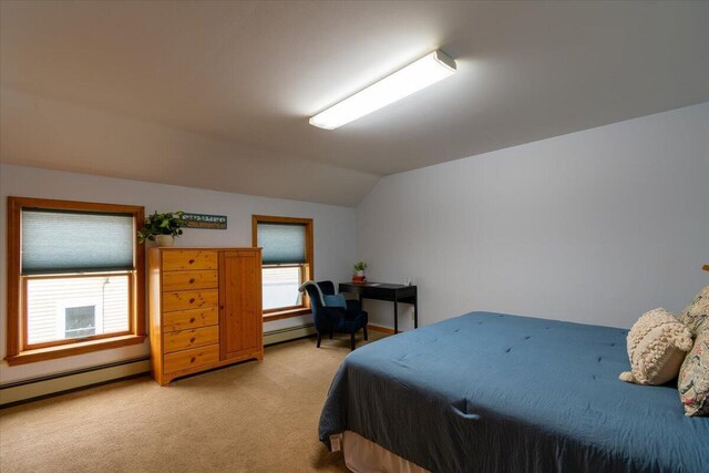 carpeted bedroom with baseboard heating and vaulted ceiling