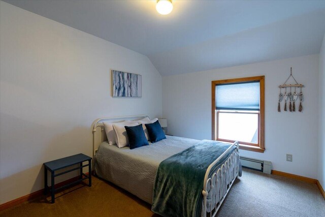 bedroom featuring lofted ceiling, a baseboard heating unit, and carpet