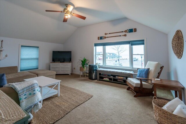 living room with lofted ceiling, ceiling fan, and carpet flooring