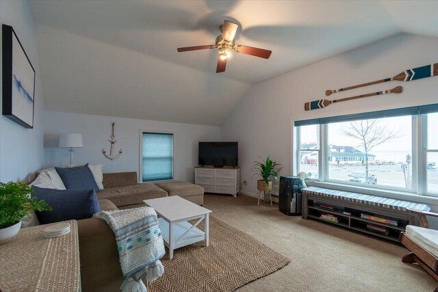 carpeted living room featuring ceiling fan and vaulted ceiling