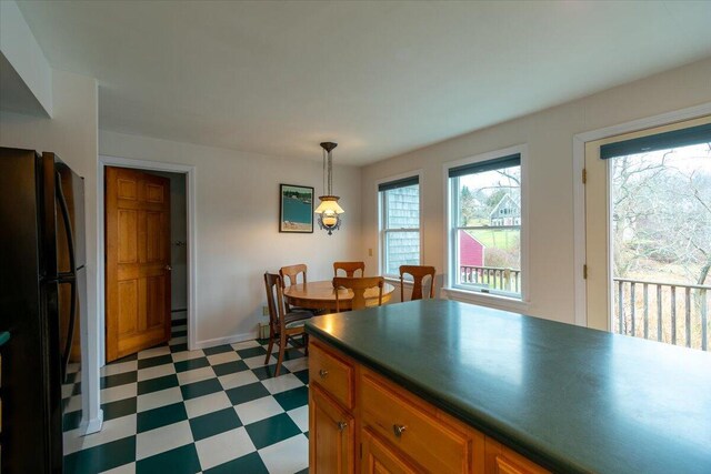 kitchen with black refrigerator and pendant lighting