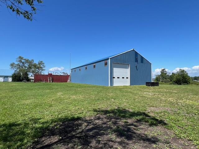 view of outbuilding with a yard and a garage