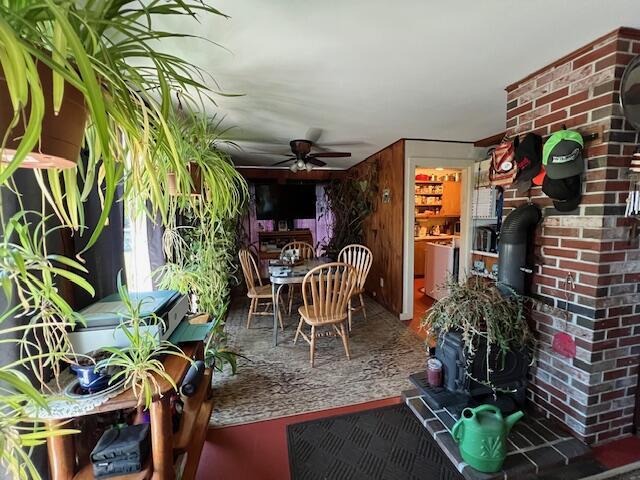 exterior space with ceiling fan and wooden walls