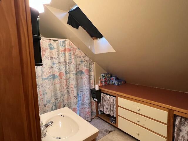 bathroom featuring vaulted ceiling and sink