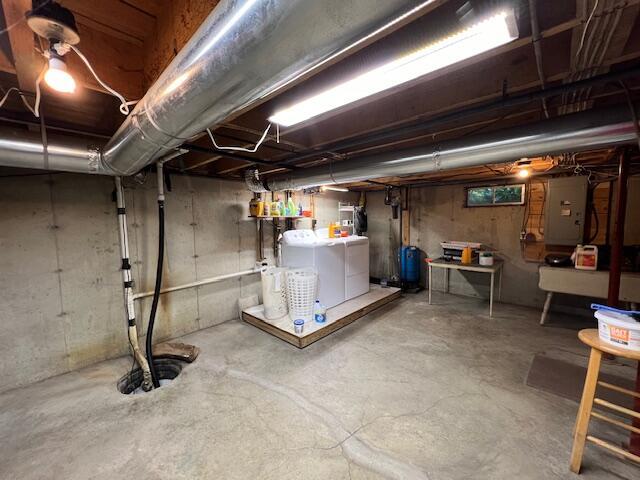 basement with electric panel and washing machine and dryer