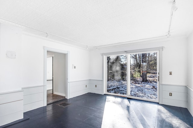 unfurnished room with dark wood-type flooring and track lighting