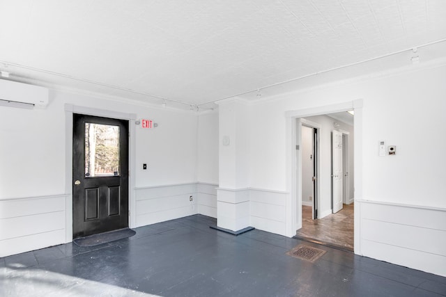 interior space featuring track lighting and a wall unit AC