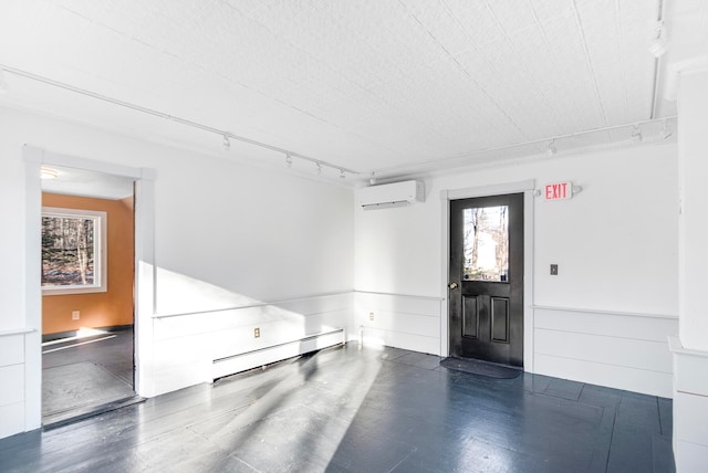 interior space with a baseboard heating unit, rail lighting, and an AC wall unit