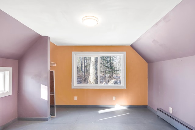 additional living space featuring vaulted ceiling and a baseboard heating unit