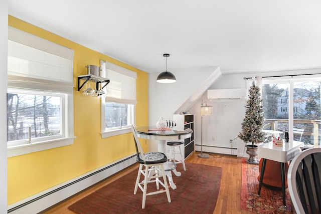 dining area featuring baseboard heating, plenty of natural light, a wall mounted AC, and hardwood / wood-style floors