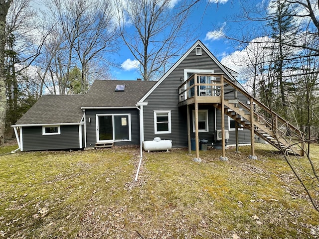 rear view of property featuring a wooden deck and a lawn