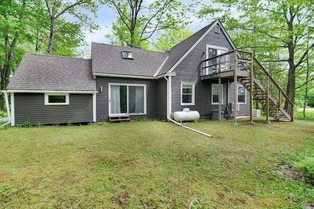 back of house featuring a deck and a lawn