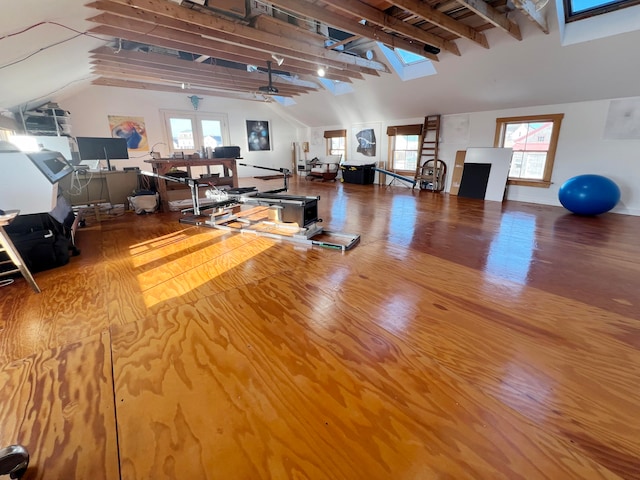 miscellaneous room featuring ceiling fan, vaulted ceiling with skylight, and hardwood / wood-style floors