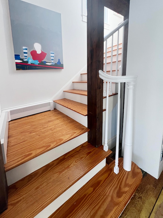 staircase with a baseboard heating unit