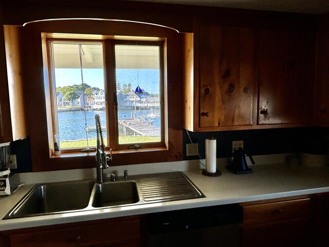 kitchen featuring dishwasher, a water view, and sink