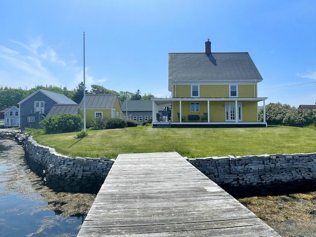 back of house featuring a yard and french doors