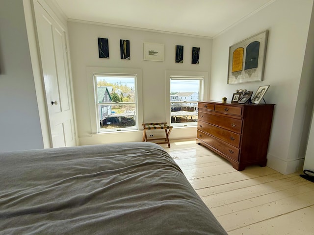 bedroom featuring crown molding and light wood-type flooring