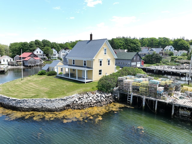 27 Clamshell Aly, Vinalhaven, ME 04863 - rear view of property featuring a water view, a yard, a metal roof, and a residential view