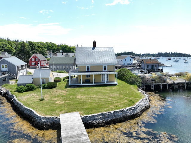 27 Clamshell Aly, Vinalhaven, ME 04863 - back of property with a water view, a chimney, a metal roof, a residential view, and a yard