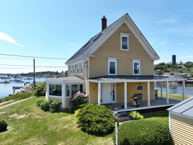 27 Clamshell Aly, Vinalhaven, ME 04863 - farmhouse featuring a standing seam roof, a front yard, a metal roof, and a water view